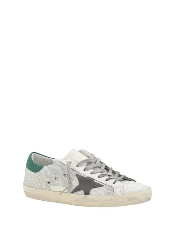 White low-top designer sneakers with black star detail and green heel accent, casual luxury footwear for men and women, Lux Brands style.