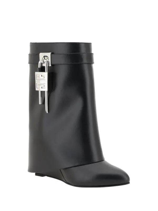 Luxury black leather ankle boot with decorative silver buckle and zipper detail for stylish and sophisticated looks.