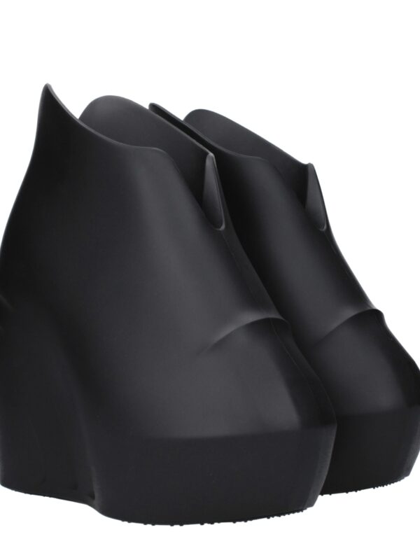 Black high-heeled ankle boots with a sleek, modern design, featuring a pointed toe and sculpted silhouette for a chic, avant-garde look. Perfect for stylish and edgy fashion statements.
