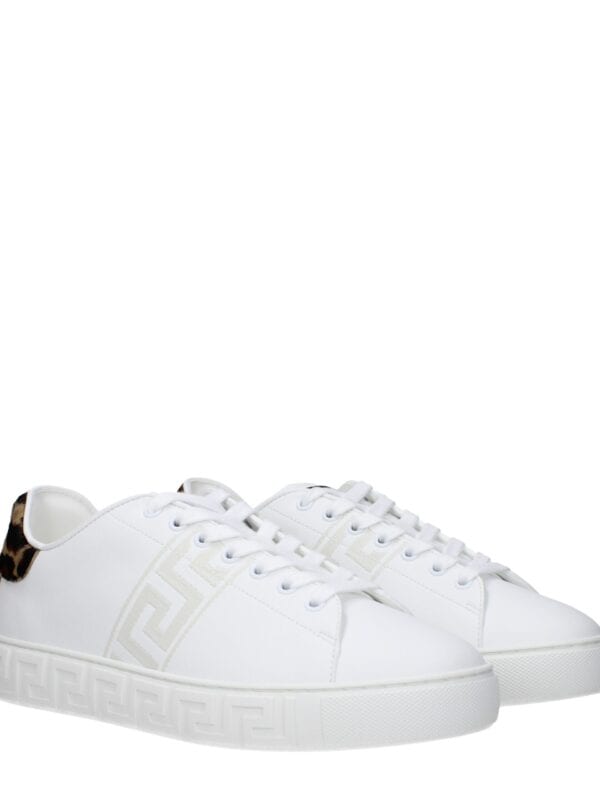 Luxurious white sneakers with animal print accents and Greek key detailing, perfect for stylish casual wear and making a bold fashion statement.