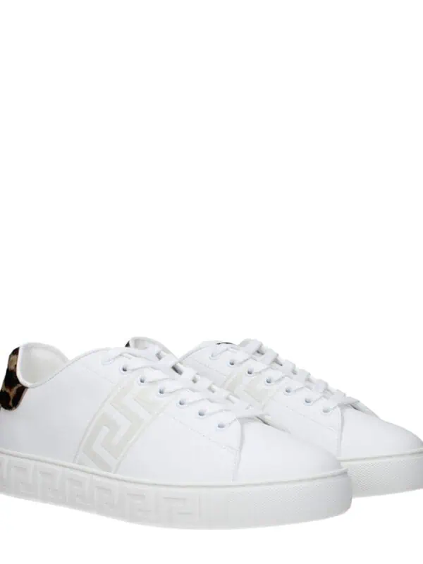 Luxurious white sneakers with animal print accents and Greek key detailing, perfect for stylish casual wear and making a bold fashion statement.