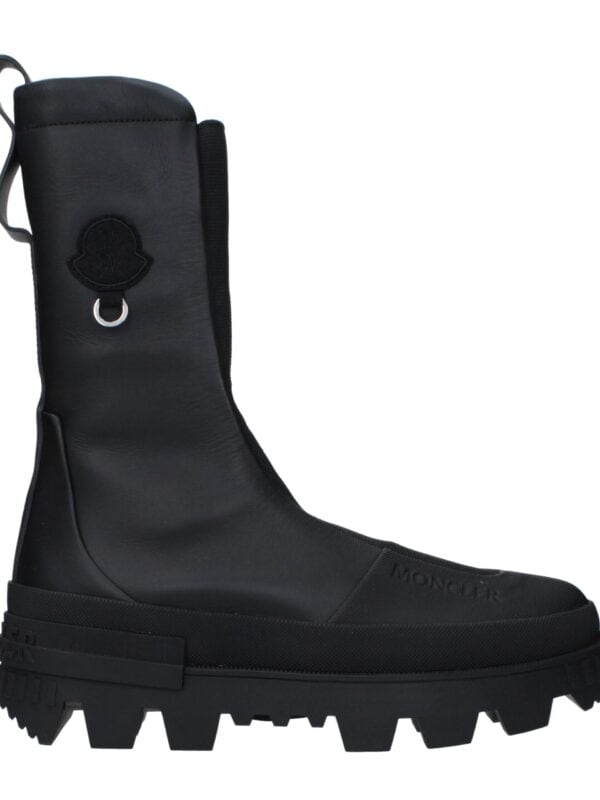 Black Moncler high-top waterproof boots with rugged sole and logo detail for luxury outdoor footwear.