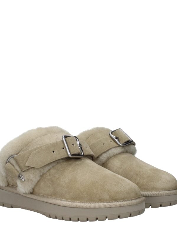 Cozy beige shearling-lined suede ankle boots with adjustable buckle straps and chunky soles, perfect for stylish winter comfort.