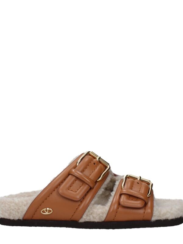 Lux Brands cozy brown shearling slippers with leather straps and gold buckle details, perfect for stylish indoor comfort.