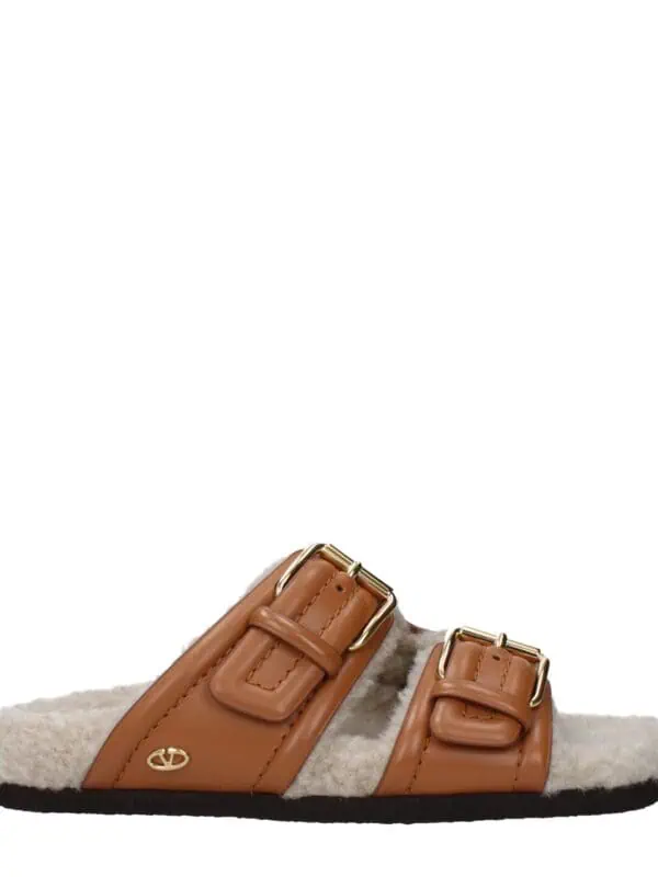 Lux Brands cozy brown shearling slippers with leather straps and gold buckle details, perfect for stylish indoor comfort.