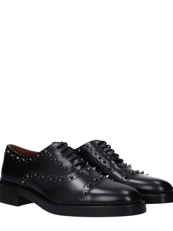 Polished black leather dress shoes with silver studs, pointed toe, lace-up design, perfect for stylish formal occasions.