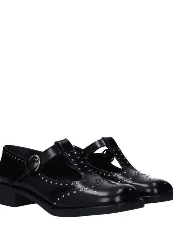 Elegant black leather Mary Jane shoes with perforated details and a buckle strap, perfect for sophisticated, stylish outfits.
