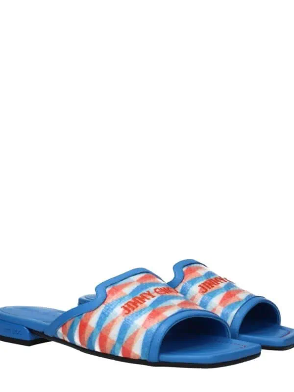 Bright blue Jimmy Choo slide sandals with multicolored striped fabric straps featuring the brand logo for a bold, stylish summer look.