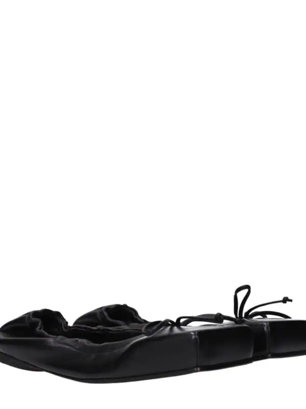 Luxury black leather ballet flats with elasticized ruffle detailing and adjustable lace ties for a stylish and comfortable fit. Perfect for everyday wear and elegant casual looks.