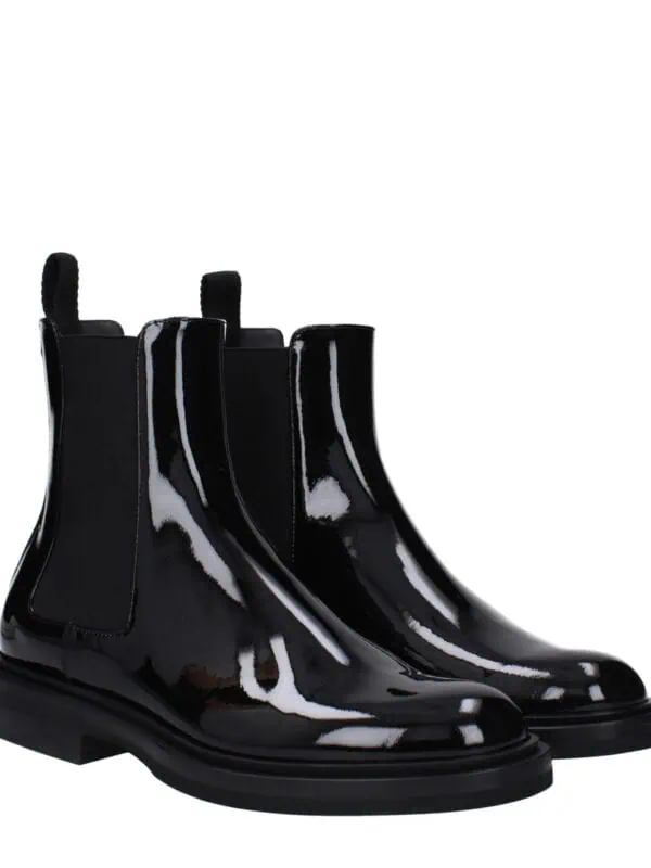 Black glossy Chelsea boots with elastic side panels and pull tabs, stylish and versatile footwear for casual or formal outfits. Perfect for a modern, edgy look.