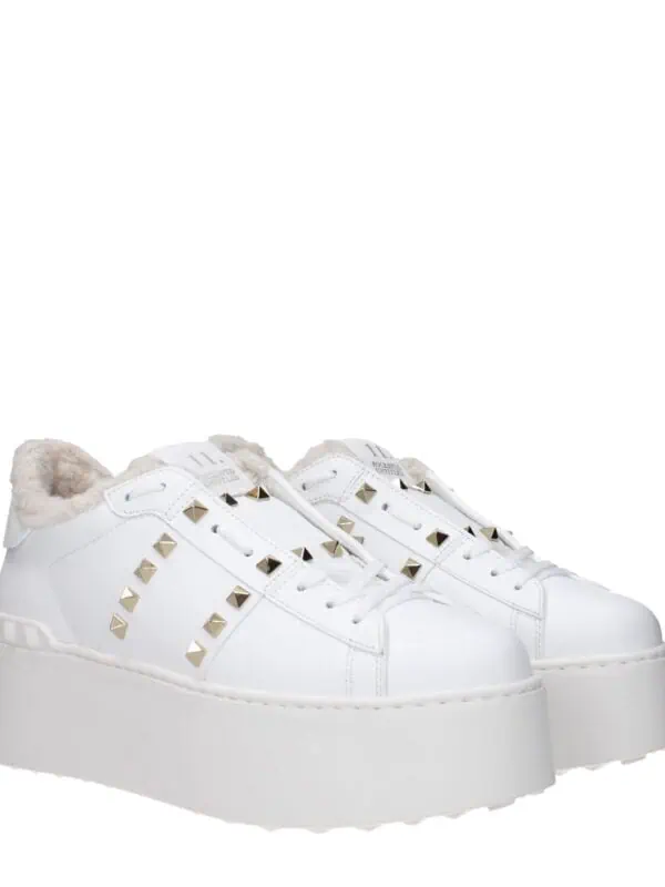 1. Stylish white platform sneakers with gold-tone pyramid studs and faux fur lining, perfect for trendy casual wear.