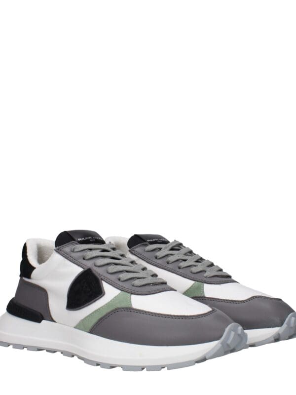 Versatile stylish sneakers featuring a mix of white, grey, black, and green accents for a modern sporty look. Perfect for casual wear and active lifestyles.