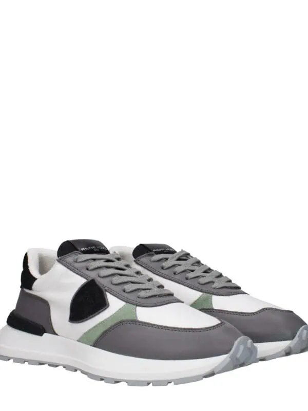 Versatile stylish sneakers featuring a mix of white, grey, black, and green accents for a modern sporty look. Perfect for casual wear and active lifestyles.