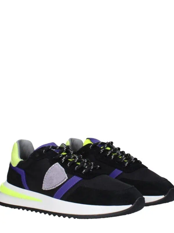 Bright black sneakers with purple accents, neon yellow heel details, and a gray patch on the side, featuring a sporty design and comfortable sole for casual wear.