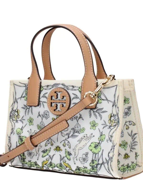 Elegant designer handbag with intricate floral and animal print, featuring tan leather handles and gold hardware, perfect for stylish accessorizing.