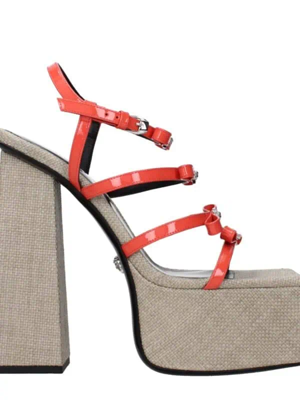 Bright coral high-heeled sandal with multiple straps featuring bow details, set on a textured beige platform and chunky heel for stylish and comfortable wear.