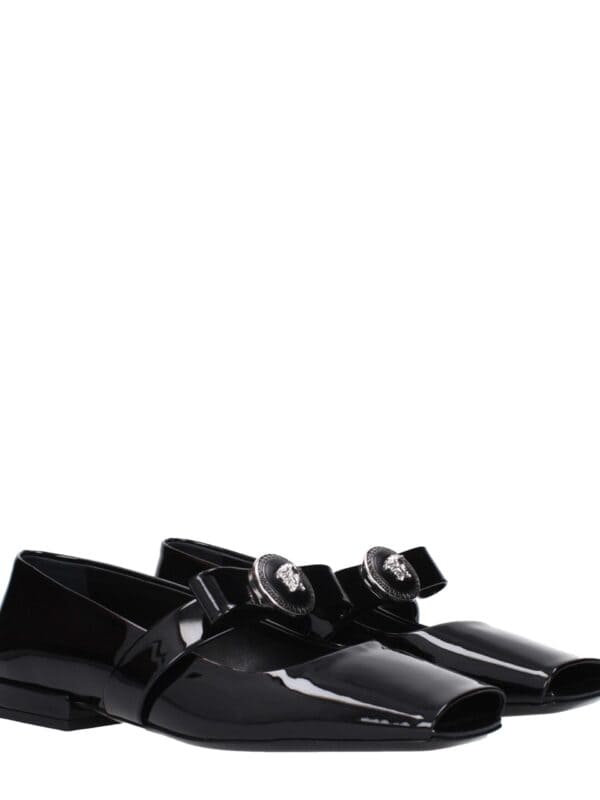 Black patent leather loafers with decorative crystal-embellished buckles, luxury design for sophisticated fashion.
