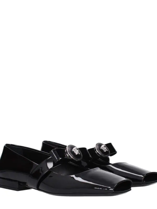 Black patent leather loafers with decorative crystal-embellished buckles, luxury design for sophisticated fashion.