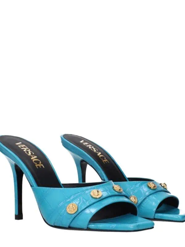 Blue Versace high-heel mules with gold Medusa head embellishments, crafted with luxurious crocodile-embossed leather for an elegant and bold statement.