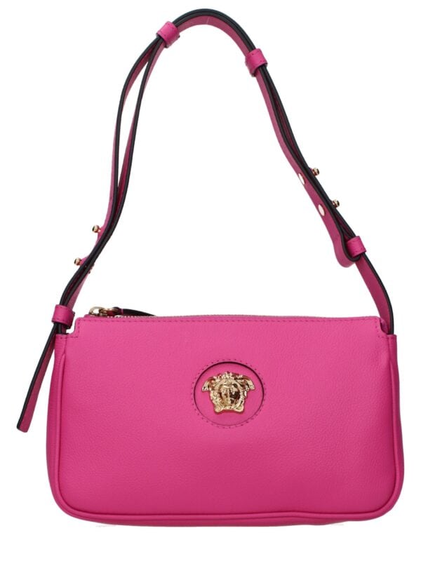 Pink leather handbag with gold lion head logo, adjustable strap, luxury fashion accessory.