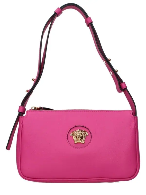 Pink leather handbag with gold lion head logo, adjustable strap, luxury fashion accessory.