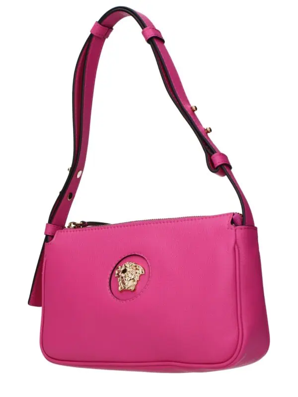 Pink leather designer handbag with gold Medusa logo on front, adjustable strap, and zip closure, perfect for luxury fashion and everyday use.