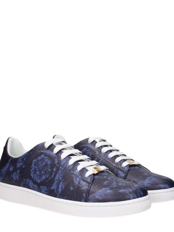 Patterned luxury sneakers with floral design and white soles, featuring gold accents on the lace tips, perfect for high-end casual style.