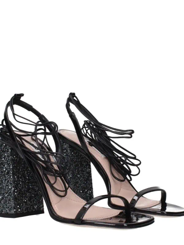 Stunning black high-heeled sandals with intricate strap design and glittery block heel, perfect for glamorous nights out and special occasions.