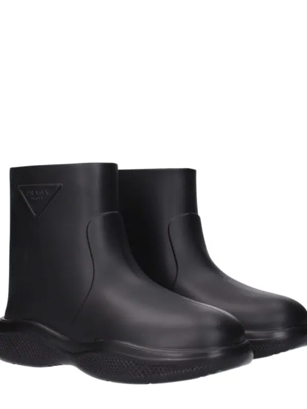 Black Prada rubber ankle boots, sleek waterproof design with textured soles and iconic Prada logo, perfect for stylish rainy day wear.