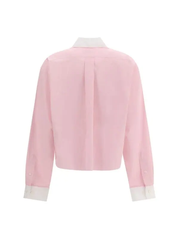 Soft pink oversized button-up shirt with white accents, classic collar, and long sleeves. Perfect for a stylish, casual elegant look or sophisticated office wear.