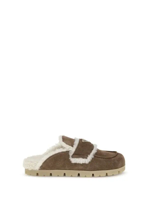 Comfortable brown shearling slippers with adjustable strap and cozy lining for indoor and outdoor wear. Perfect for cold weather and lounging at home.