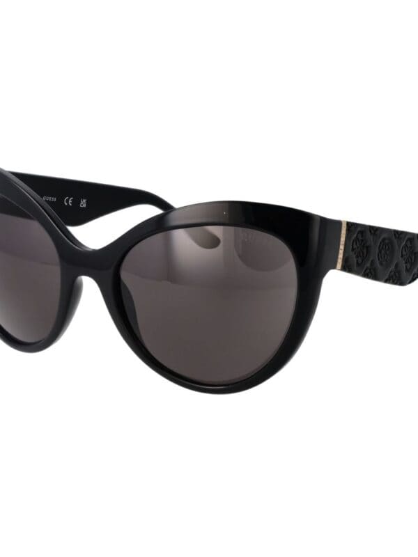 Black designer sunglasses with dark lenses, stylish frame, and branded patterned arms for a luxurious and trendy look.