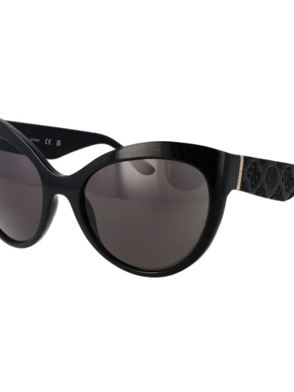 Black designer sunglasses with dark lenses, stylish frame, and branded patterned arms for a luxurious and trendy look.