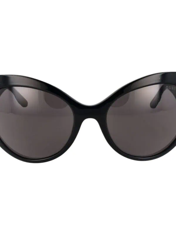 Black stylish oversized cat-eye sunglasses by Guess with dark tinted lenses for a chic, fashionable look. Perfect for sun protection and making a statement.