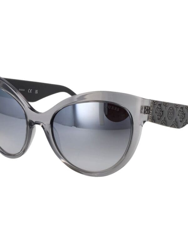 Silver and black Guess sunglasses with gradient lenses, trendy design, and patterned temples for a fashionable sun protection accessory.
