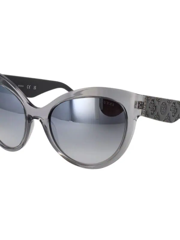 Silver and black Guess sunglasses with gradient lenses, trendy design, and patterned temples for a fashionable sun protection accessory.