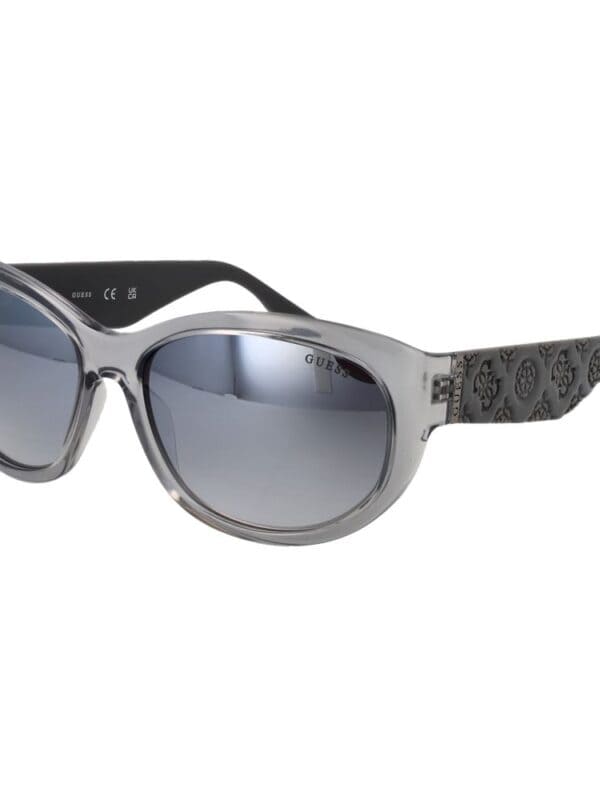 GUESS sunglasses with a stylish transparent frame and dark tinted lenses, perfect for a trendy summer look.