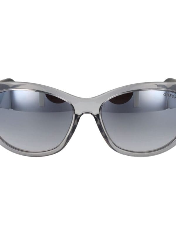 Sunglasses with a sleek, modern design featuring gradient lenses and a transparent gray frame by Guess. Perfect for fashion-conscious individuals seeking stylish sun protection.