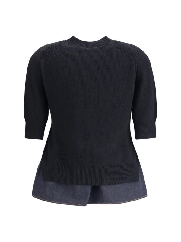 Luxury black oversized knit sweater with a classic crew neckline and 3/4 sleeves, paired with dark denim shorts, ideal for stylish casual wear.