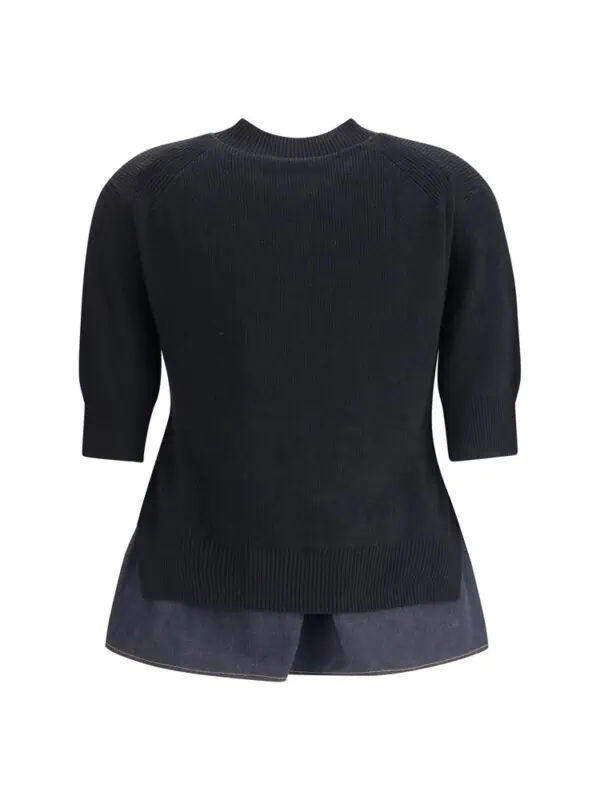 Luxury black oversized knit sweater with a classic crew neckline and 3/4 sleeves, paired with dark denim shorts, ideal for stylish casual wear.