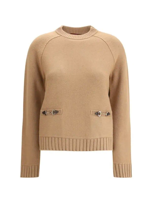 Soft beige sweater with metal buckle details and ribbed cuffs and hem, perfect for stylish winter wear.