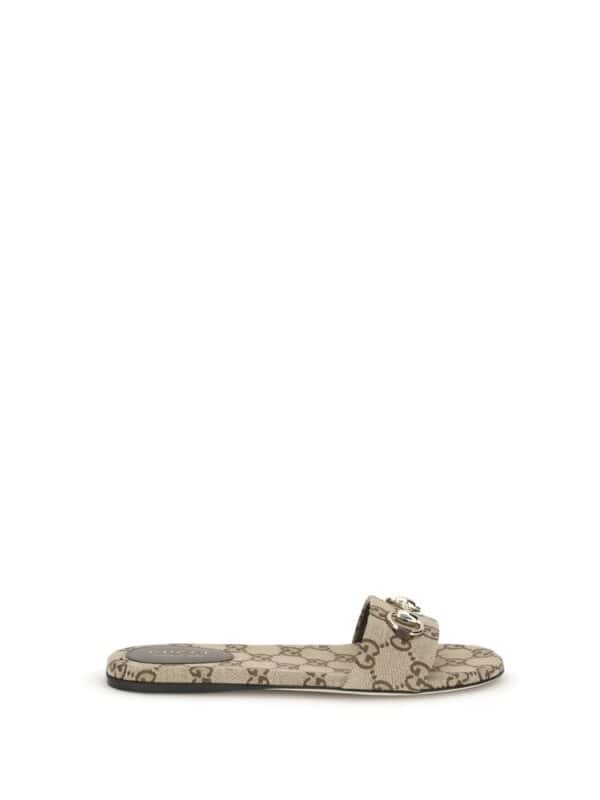 Designer Gucci logo slide sandal in beige with monogram print and silver buckle detail. Perfect for casual luxury style and comfortable everyday wear.