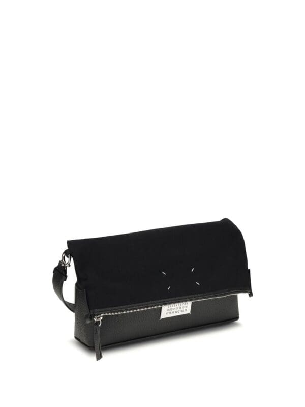 Black designer clutch bag with zip closure and adjustable strap for versatile styling.