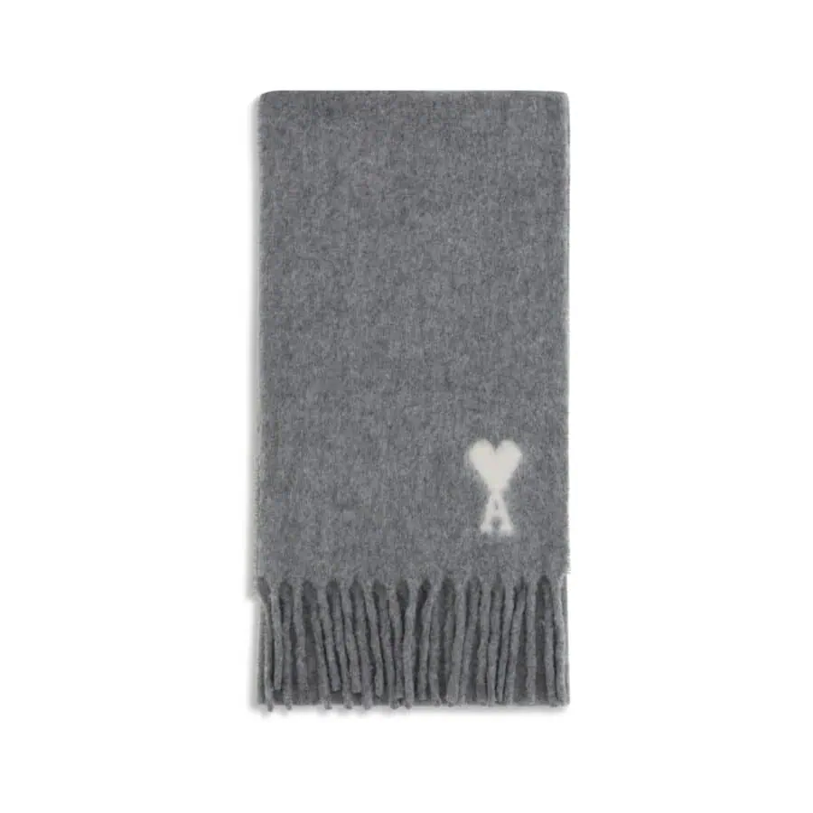 Soft grey scarf with a white heart and "A" monogram, featuring fringed ends, ideal for stylish winter fashion.