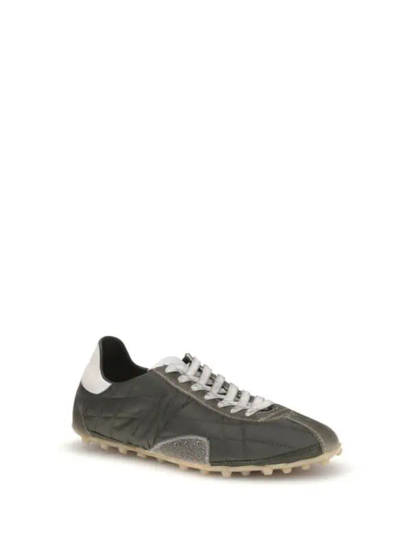 Designer sneaker with black, white, and grey accents, featuring a textured sole and stylish stitching, perfect for casual and athletic wear.