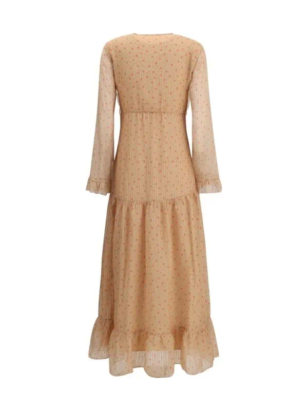 Flowy peach-tiered maxi dress with long puff sleeves, delicate dotted pattern, and ruffled hem, perfect for elegant spring or summer occasions.