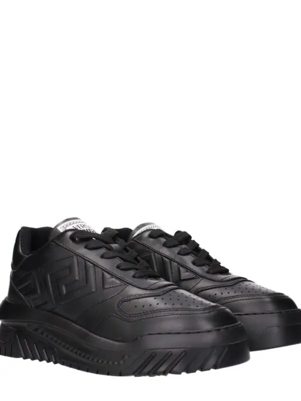 Black luxury designer sneakers with a bold, chunky sole and embossed logo details, perfect for high-end fashion looks.