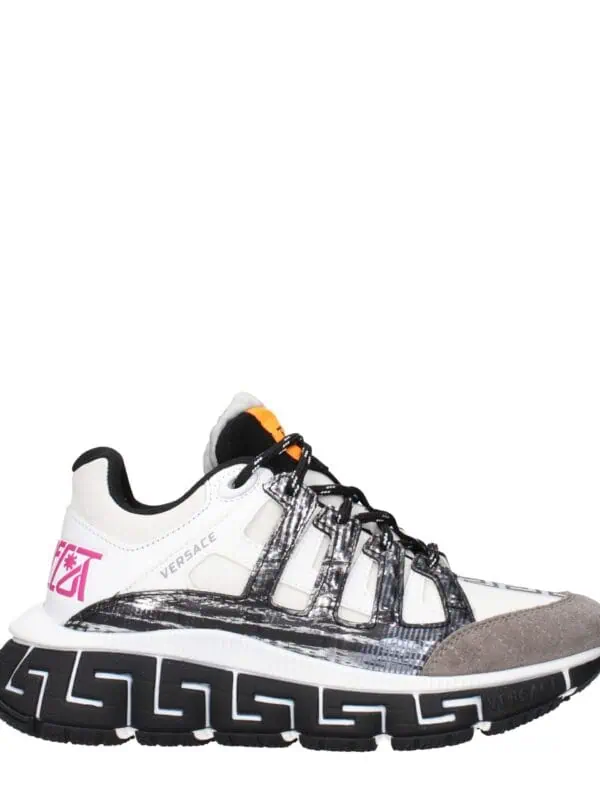 Bold designer sneakers with a mix of white, black, gray, and orange accents, featuring a chunky sole and graphic details from Versace.