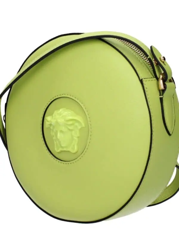Bright lime green Versace round leather handbag with Medusa head emblem, gold hardware, and adjustable strap. Perfect for adding a pop of color and luxury to your outfit.