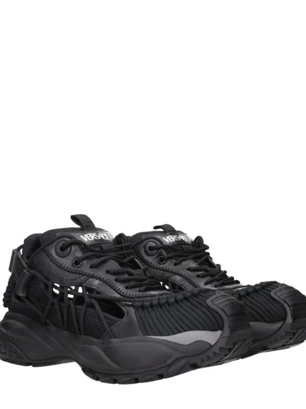 Versace black designer sneakers with intricate detailing, mesh features, and a chunky sole, perfect for luxury streetwear style.